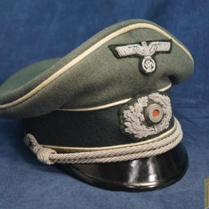 The visor is in great structural condition with no major damage or bill separation. The embroidered eagle and wreath are oxidation free and show some light wear. There are few areas with moth tracking but no holes that go straight through. The white piping is great as well with only a few hard to notice moth spots. The inside is very nice with no issues. The sweat band is in great shape with no rips. Behind it, the cork pad is in good shape. A nice nearly mint example!